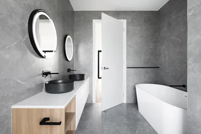 Premium stone tile and gold fixtures in high-value bathroom renovation