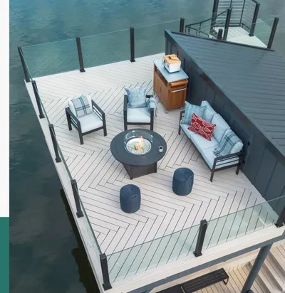 Aerial of an over-water composite deck with herringbone Trex Transcend Lineage decking and frameless glass railing