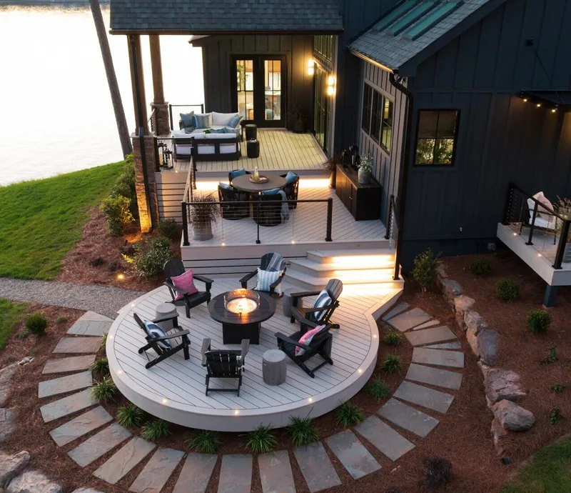 Multi-level lakeside composite deck with integrated step lighting, fire pit lounge, and dining area