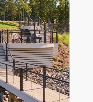 Multi-level composite walkway with stainless steel cable infill railing on a hillside lot