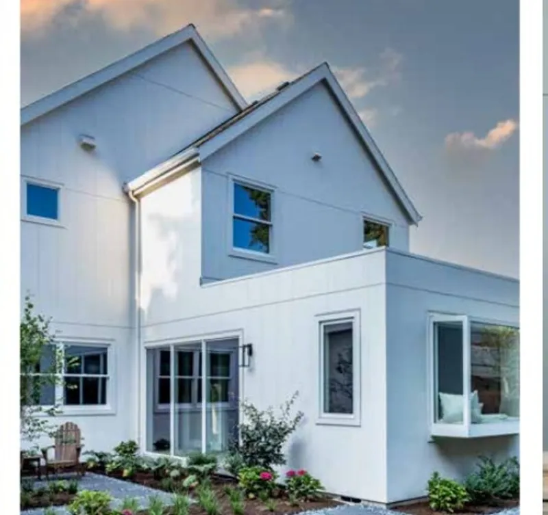 Modern white James Hardie architectural panel home with two pitched roofs and large windows