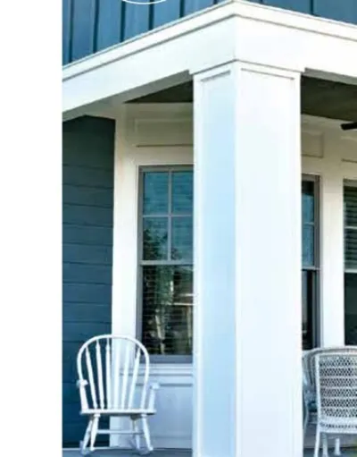 Blue board-and-batten porch corner with white columns and trim on a coastal-style home