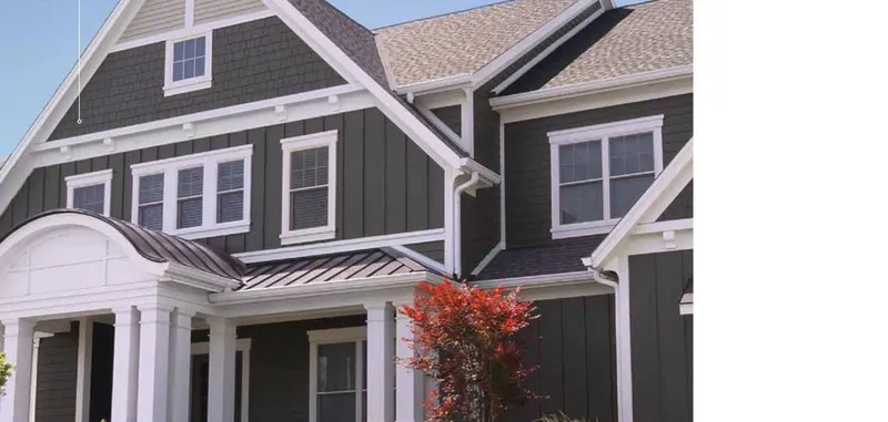 Complete exterior in James Hardie fiber cement siding — board-and-batten, shingle, and trim in dark gray with white accents on a craftsman-style home